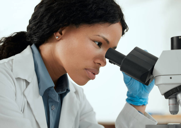 Shes bereit, die Arbeit zu erledigen. eine junge Frau unter dem Mikroskop in einem wissenschaftlichen Labor - Foto, Bild