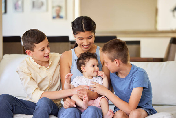 Multiracial family at home. Mother with her adoptive sons. Young mixed race mother relaxing with her children. Diverse blended family relaxing together at home. Boys spending time with their sister. - Photo, image