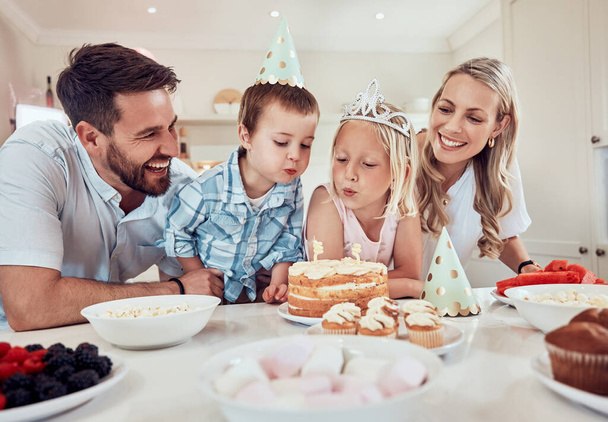 Šťastná rodina slaví narozeniny dcer. Holčička sfoukává svíčky na narozeninovém dortu. Bratr a sestra slaví narozeniny oslavou. Kavkazská rodina na narozeninové oslavě. - Fotografie, Obrázek