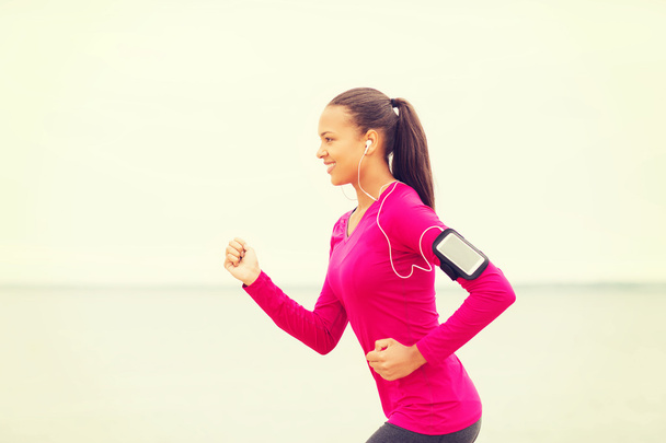 smiling young woman running outdoors - Photo, image