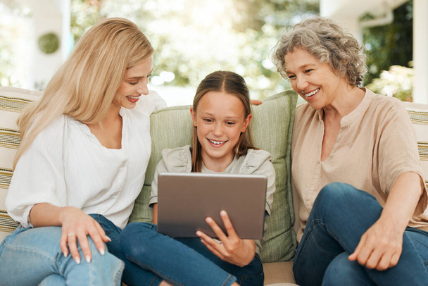 Technology brings family together. a grandmother spending time with her daughter and granddaughter while using a digital tablet - Foto, immagini