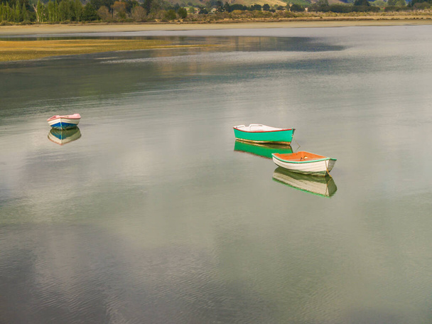 Scenic Kenepuru Sound images of water's edge and three dinghy boats afloat and reflected in Marlborough Sounds New Zealand. - 写真・画像