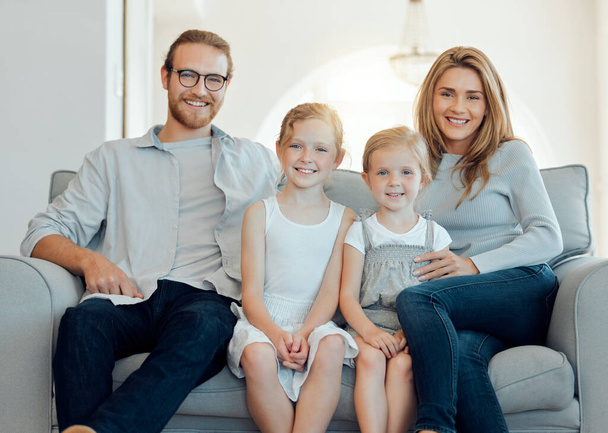 Eine gemeinsame Welt. eine junge Familie, die sich zu Hause glücklich auf dem Sofa zusammenklebt - Foto, Bild