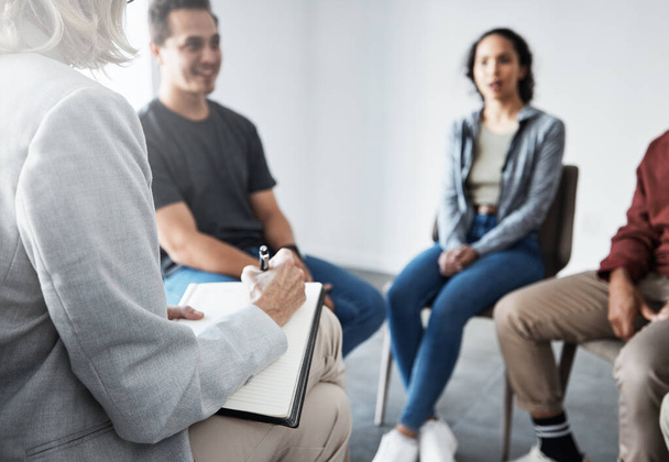 Group therapy. Therapist talking to patients together. Group of people in therapy. Diverse people talking to psychologist. People in treatment with a therapist. Counsellor in a therapy session. - Photo, Image