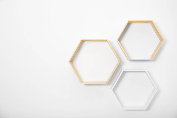 Empty honeycomb shaped shelves on white wall, space for text - Valokuva, kuva