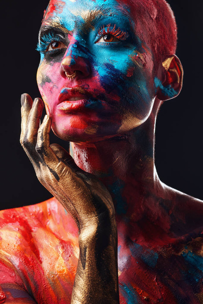 Kunst vangt de ziel. een aantrekkelijke jonge vrouw poseren alleen in de studio met verf op haar gezicht en lichaam - Foto, afbeelding