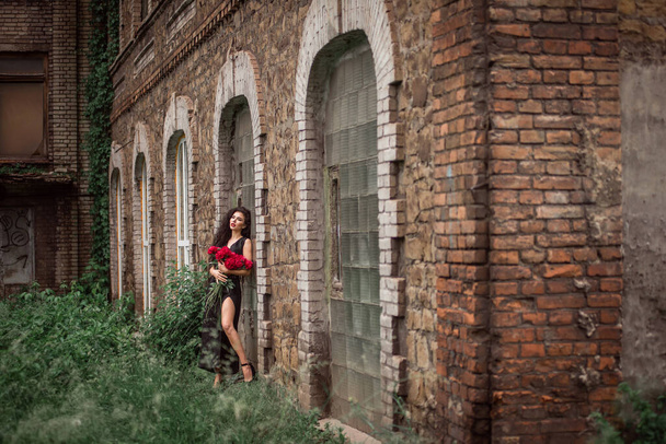 fiatal gyönyörű nő piros ruhában, hátizsákkal a háttérben a régi vár - Fotó, kép