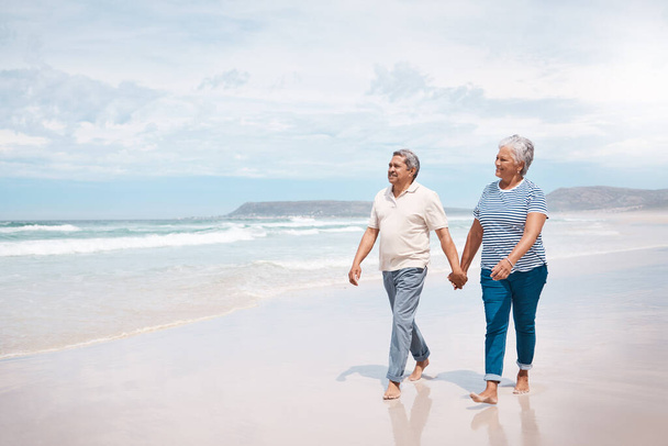Nothing feels better than a walk on the beach. a senior couple taking a walk on the beach - Foto, Bild