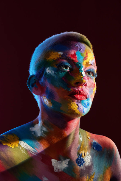 Be uniquely you. Stand out. Shine. Be colorful. Studio shot of a young woman posing with multi-coloured paint on her face - Φωτογραφία, εικόνα