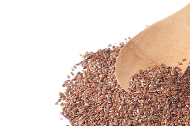 semillas de lino con una cuchara de madera sobre fondo blanco
 - Foto, Imagen