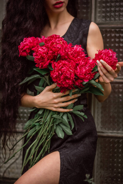 gyönyörű fiatal nő csokor virággal a kezében - Fotó, kép