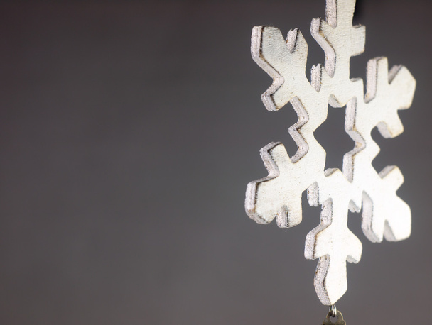 Ξύλινο Χριστουγεννιάτικο στολίδι σε σχήμα μια νιφάδα χιονιού. - Φωτογραφία, εικόνα