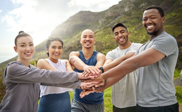 Staying fit and enjoying the journey together. Portrait of a group of sporty young people joining their hands together in a huddle - Foto, Imagen