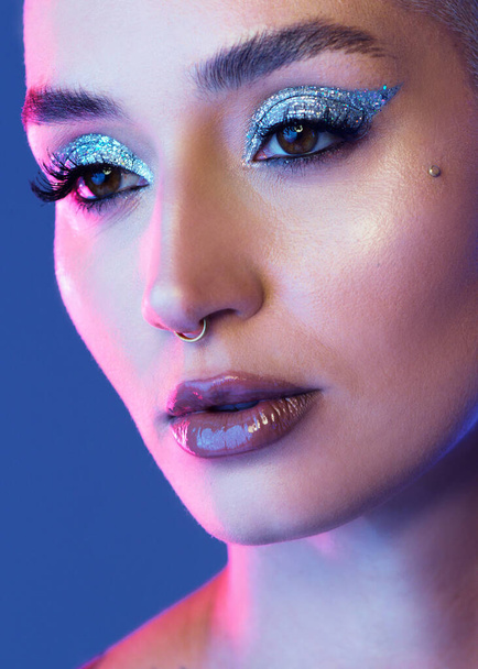 I prefer anything bold. Studio shot of an attractive young woman wearing edgy makeup against a blue background - 写真・画像