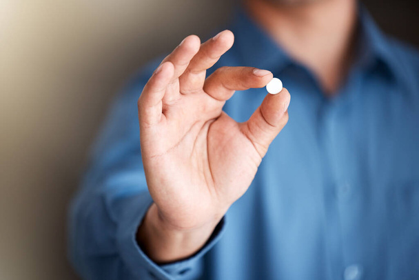 For those extra long days. a businessman holding a vitamin pill - Foto, afbeelding