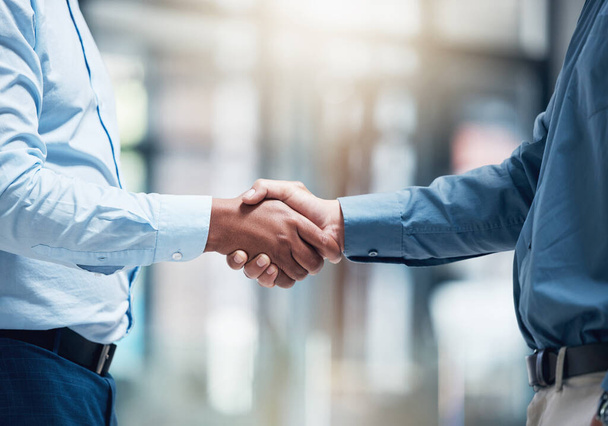 Id just like to say congratulations. two unrecognizable businesspeople shaking hands in an office at work - Foto, immagini