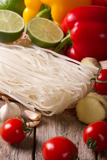 Dry rice noodles with fresh vegetables on a table vertical - Photo, Image