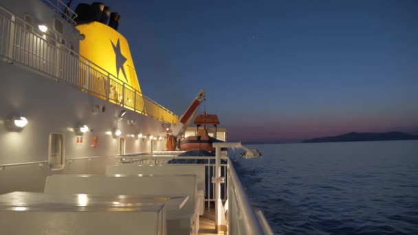 On board the cruise ship that takes us to the island of Amorgos, we can see the sea with the night light at sunset, wide shot, big boat with chimney - Footage, Video
