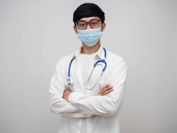 Доктор в медицинской маске и очках стоя крест руку портрет - Фото, изображение