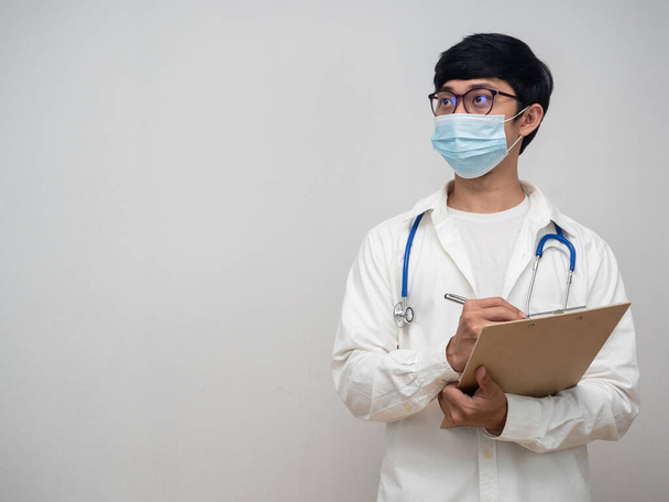 Doctor wearing mask hold check list looking at copy space - Fotó, kép