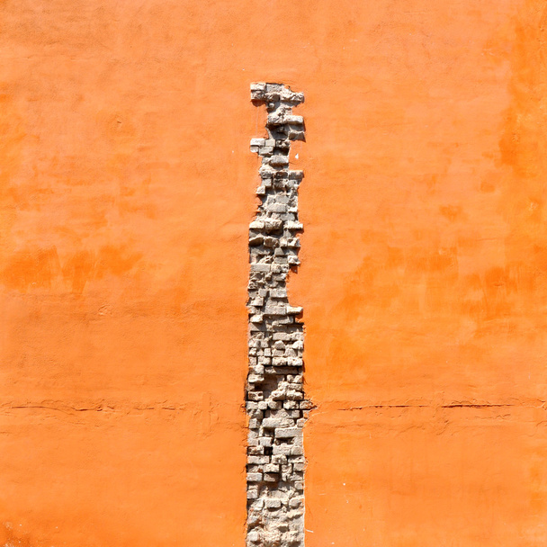 Grieta de ladrillos en pared naranja
 - Foto, imagen
