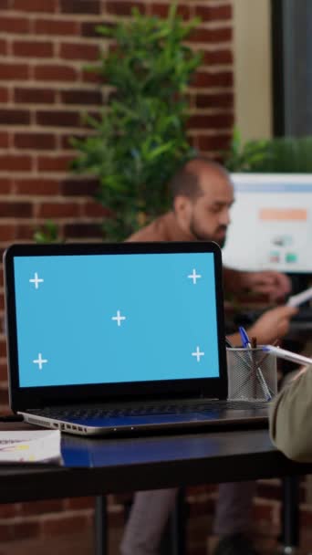 Вертикальне відео: Офісний працівник використовує ноутбук з зеленим екраном на роботі, працюючи з ізольованим порожнім шаблоном і макетним копіювальним фоном на екрані ключа хроми. Бізнес менеджер
. - Кадри, відео