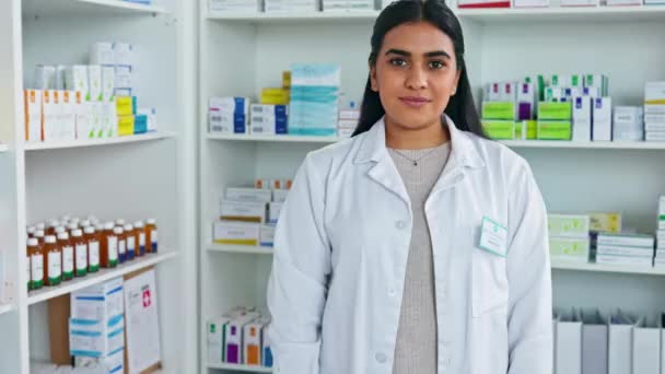 Portret van een vrouwelijke apotheker in een apotheek. Een zorgverlener die alleen staat in de apotheek met dozen pillen en tabletten op de schappen. Zelfverzekerde vrouw die met medicatie werkt. - Video