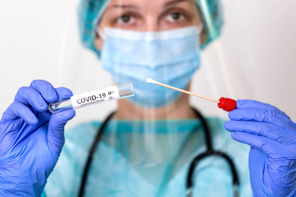 COVID-19-et tartó egészségügyi ellátás, Coronavirus tampongyűjtő készlet, PPE védőruha maszk kesztyű viselése, tesztcső OP NP betegminta vételéhez, PCR DNS vizsgálati eljárás - Fotó, kép