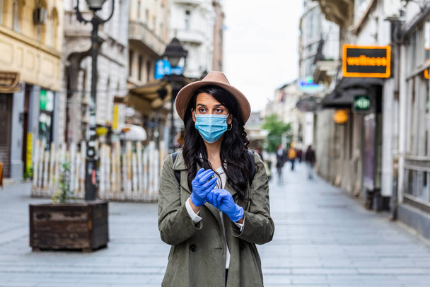 Girl in respiratory mask. Cold, flu, virus, tonsillitis, respiratory disease, quarantine, epidemic concept. Young woman on the street wearing face protective mask to prevent Coronavirus and anti-smog - Fotografie, Obrázek