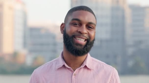 Face of a successful business man enjoying a day in the city before work. Confident african american corporate professional showing perfect teeth after good oral and dental care or hygiene routine. - Кадры, видео