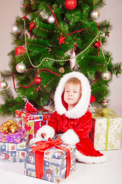 Baby in Santa costume at the Christmas tree with gifts - Foto, Bild