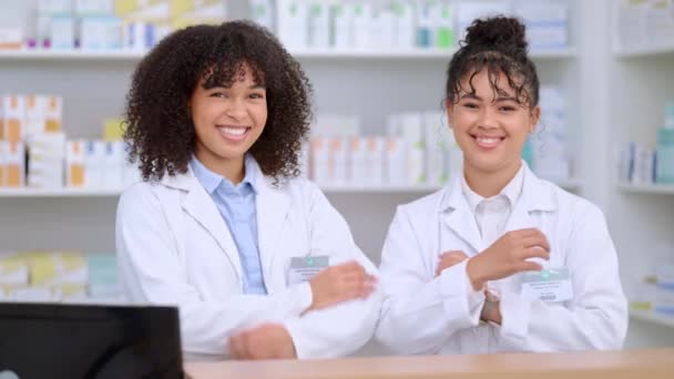 Portret van twee trotse en zelfverzekerde apothekers met gekruiste armen in een apotheek die medicijnen op recept verstrekken. Gelukkig gemotiveerde gezondheidswerkers glimlachend terwijl ze medicijnen verkopen. - Video