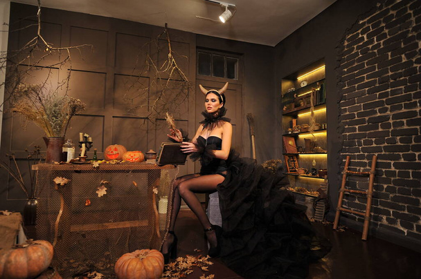 gyönyörű fiatal nő halloween jelmez boszorkány kalap és fekete macska - Fotó, kép