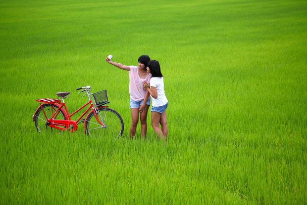 twee meisjes nemen van een foto met fiets in Sawa - Foto, afbeelding