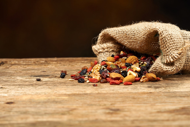 смешивать орехи и сухофрукты, на деревянном столе
 - Фото, изображение