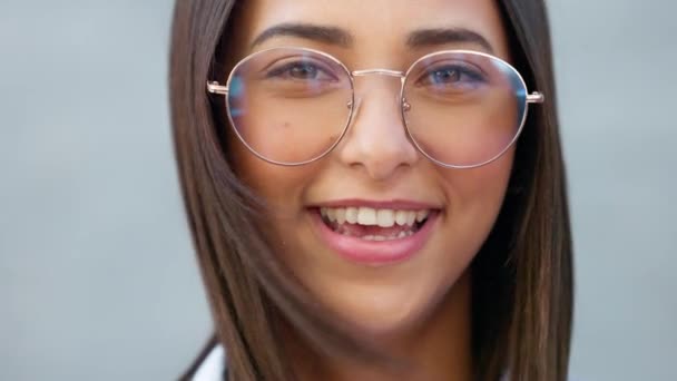 Fashionable student watching, gazing with trendy optometry vision glasses. Detail closeup portrait of funky, cool and friendly woman looking forward in city and wearing optician prescription eyewear. - Imágenes, Vídeo