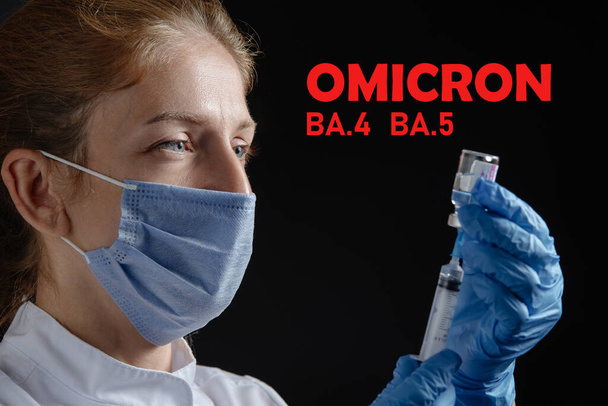 Egy női orvos a fecskendőbe szívja a vakcinát. Omicron Ba.4 és Ba.5 Védőmaszkot és kesztyűt viselő női orvos fekete háttér ellen védőoltással vagy injekcióval ellátott fecskendőt tart. - Fotó, kép