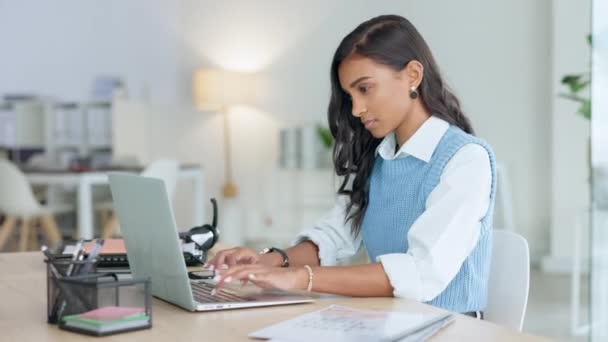 Trendy business woman typing an email on a laptop and thinking while working on a project in her office. Young journalist or female entrepreneur working on blog and trying to find inspiration online. - Кадри, відео