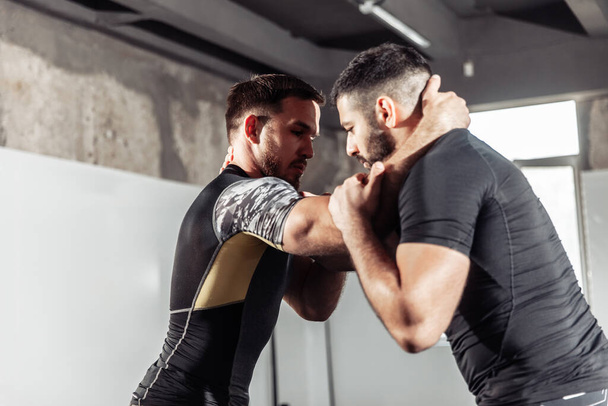 Entrenamiento de dos luchadores de mma atléticos en el gimnasio. Artes marciales, Lucha libre - Foto, imagen