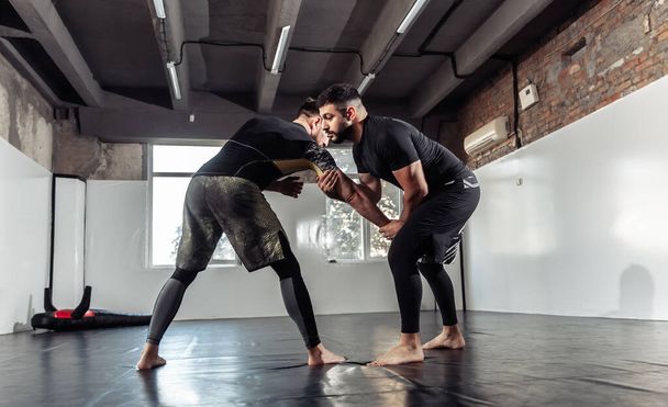 Спарринг тренировки двух атлетических бойцов мма в тренажерном зале. Боевые искусства, Борьба - Фото, изображение