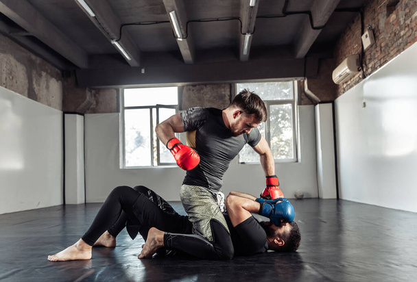 Dwóch sparingowców walczy w rękawiczkach kickboxingowych na siłowni. - Zdjęcie, obraz