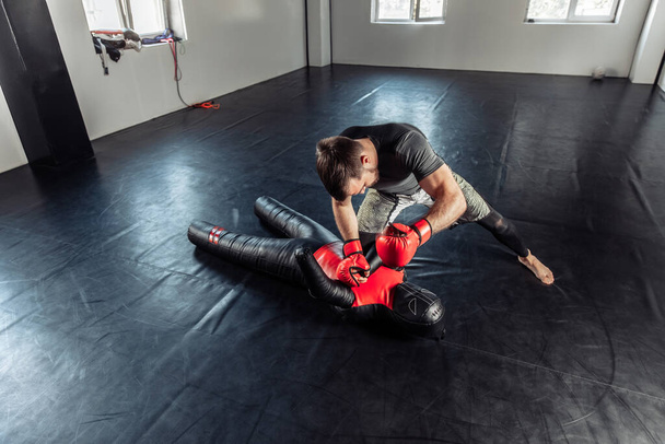 Combate MMA entrena golpes en un maniquí en un pabellón deportivo - Foto, Imagen