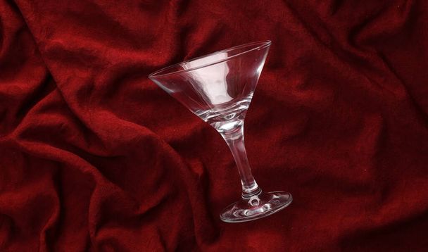 Cocktail glass on red crumpled silk background - Foto, Imagem