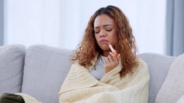 Nemocná žena měří tělesnou teplotu pomocí teploměru, který testuje vysokou horečku. Ubohé ženy se necítí dobře s chřipkou, nachlazení a kovid příznaky zatímco izolaci pod přikrývkou pro nachlazení. - Záběry, video