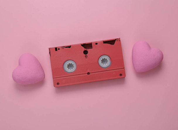 Videocassette met hartjes op een roze achtergrond. Liefdesconcept. Bovenaanzicht - Foto, afbeelding