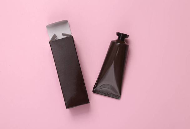 Mockup of black cream tube with box on pink background - Foto, immagini