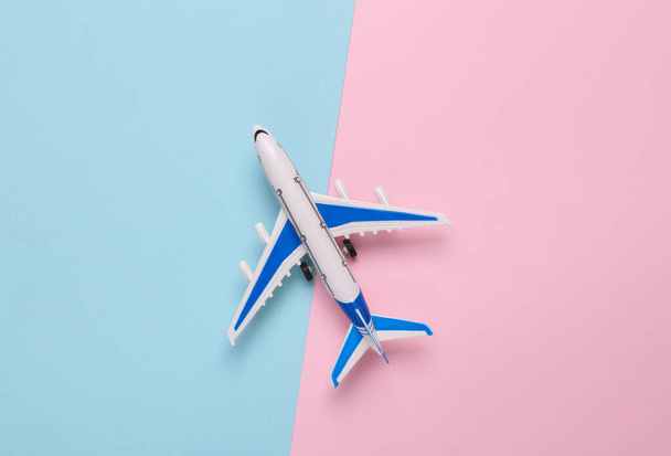 Mavi-pembe arka planda oyuncak model uçak. Seyahat konsepti. Düz yatış, üst görünüm - Fotoğraf, Görsel