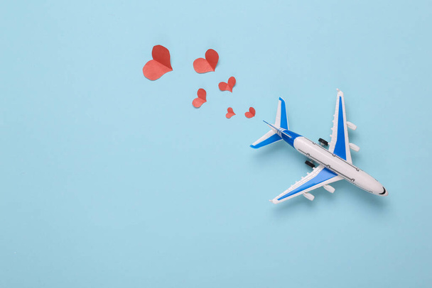 Mavi arka planda kalpleri olan oyuncak yolcu uçağı. Üst Manzara. Aşk konsepti - Fotoğraf, Görsel