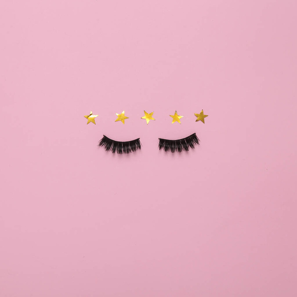 Excellent beauty service.  False eyelashes with 5 gold stars on pink background. Top view - Valokuva, kuva