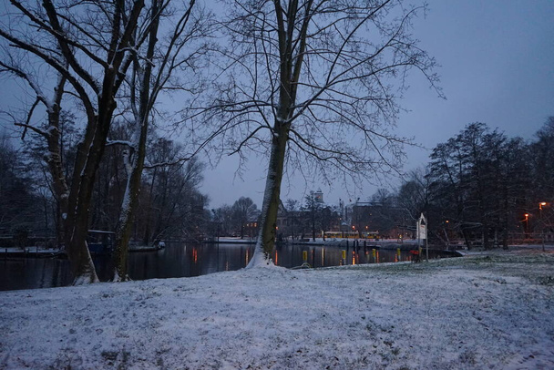 Snowy banks of the river Spree in the evening in December. Berlin, Germany - Zdjęcie, obraz